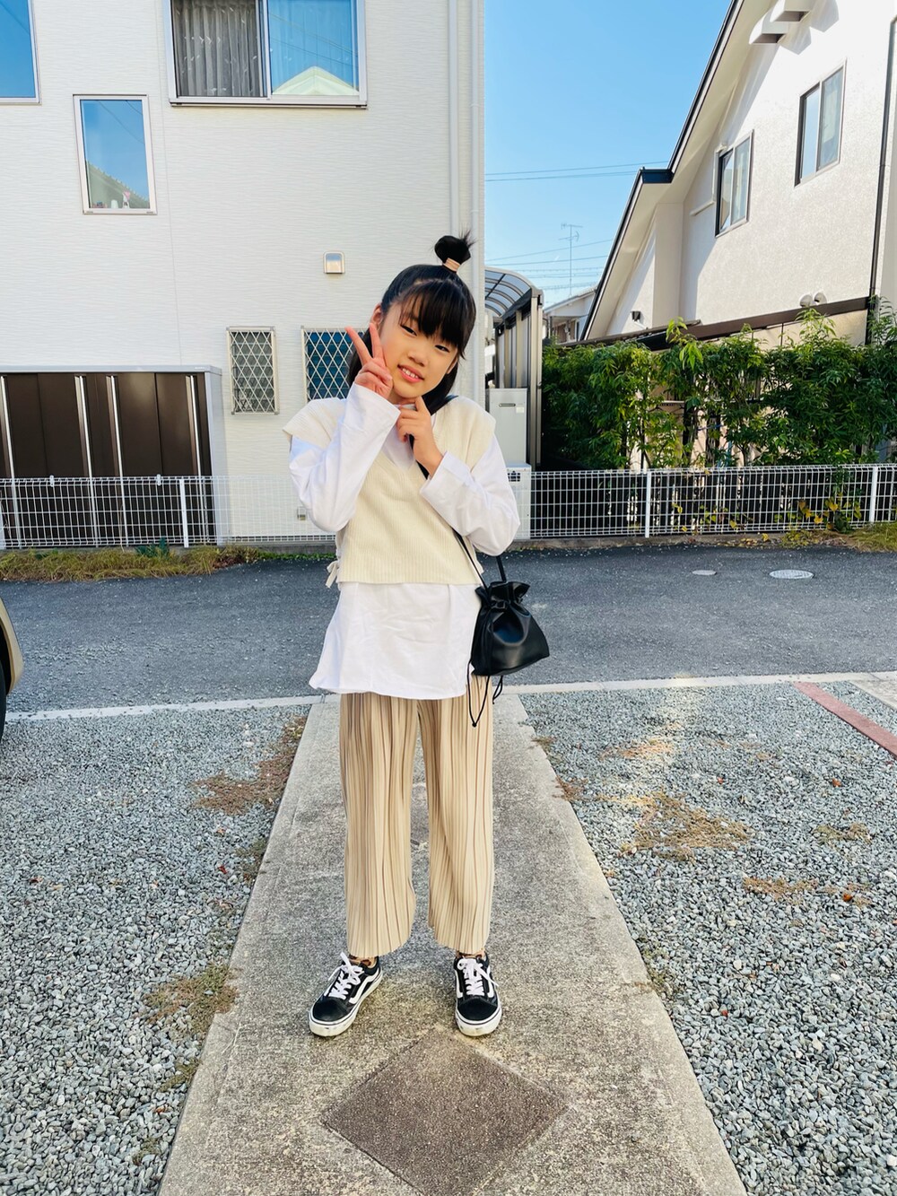 ベージュ系のその他パンツ、ブラック系のスニーカー、ホワイト系のTシャツ/カットソーを着用したキッズの秋コーディネートの2枚目の写真