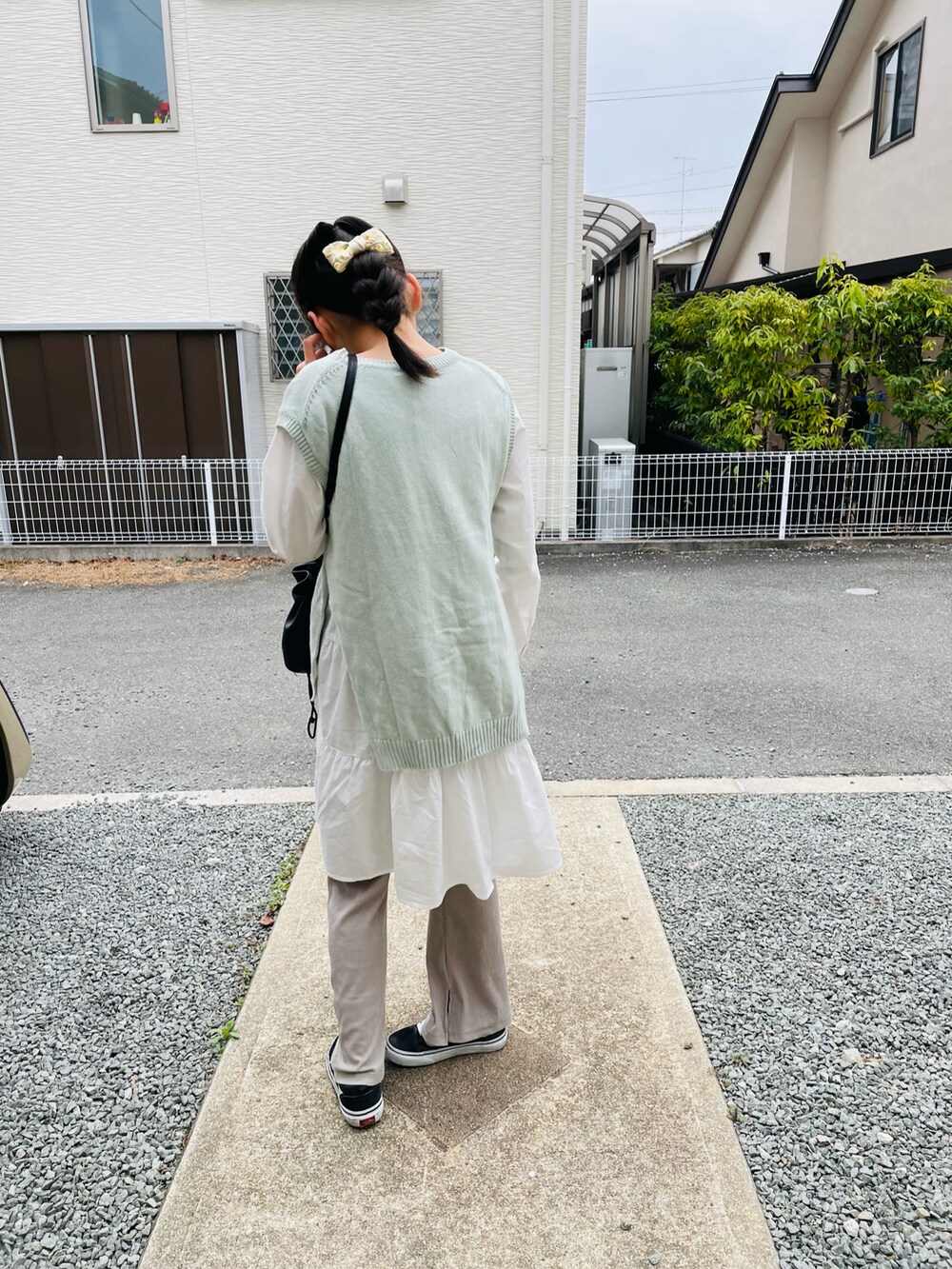 ブラック系のハンドバッグ、グリーン系のワンピース、ホワイト系のワンピースを着用したキッズの春コーディネートの4枚目の写真