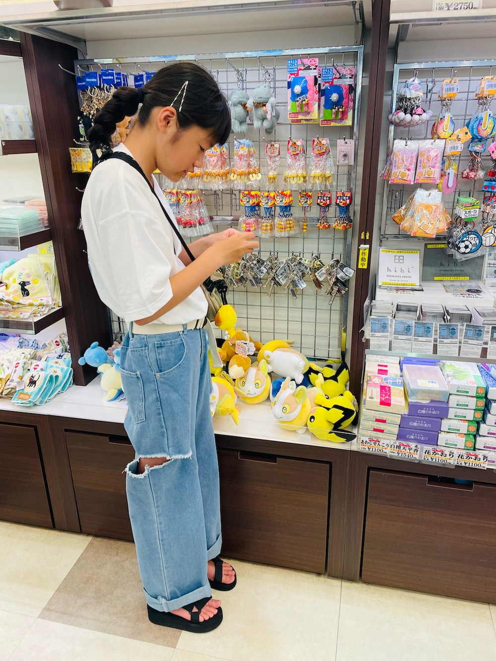 ホワイト系のTシャツ/カットソー、ブラック系のサンダル、ベージュ系のボディバッグ/ウエストポーチを着用したキッズの秋コーディネートの2枚目の写真