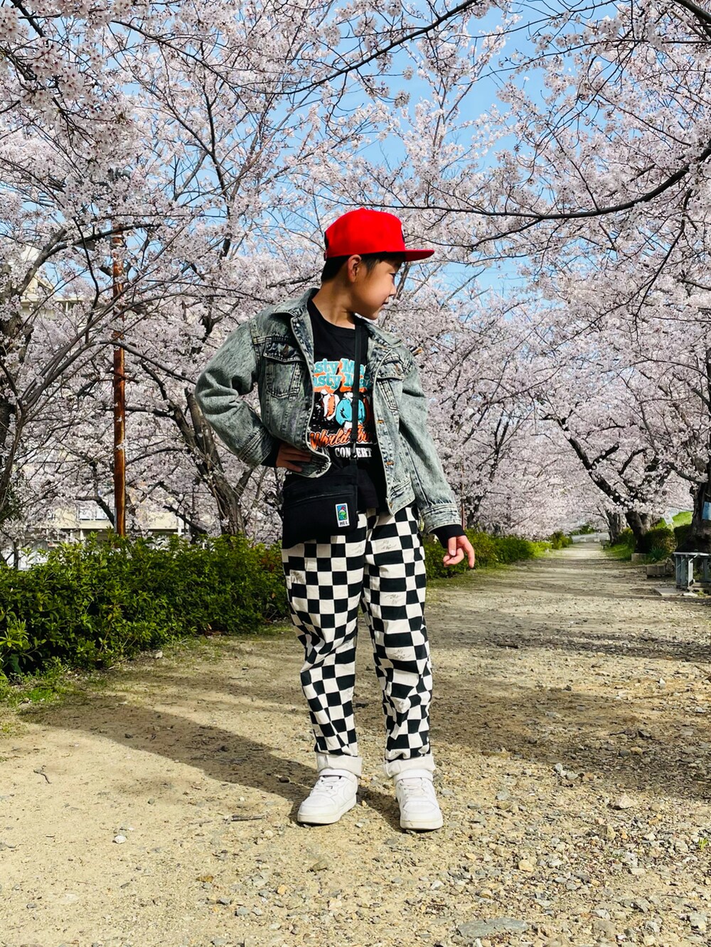 ブルー系のデニムジャケット、ブラック系のその他パンツ、ホワイト系のスニーカーを着用したキッズの春コーディネートの3枚目の写真