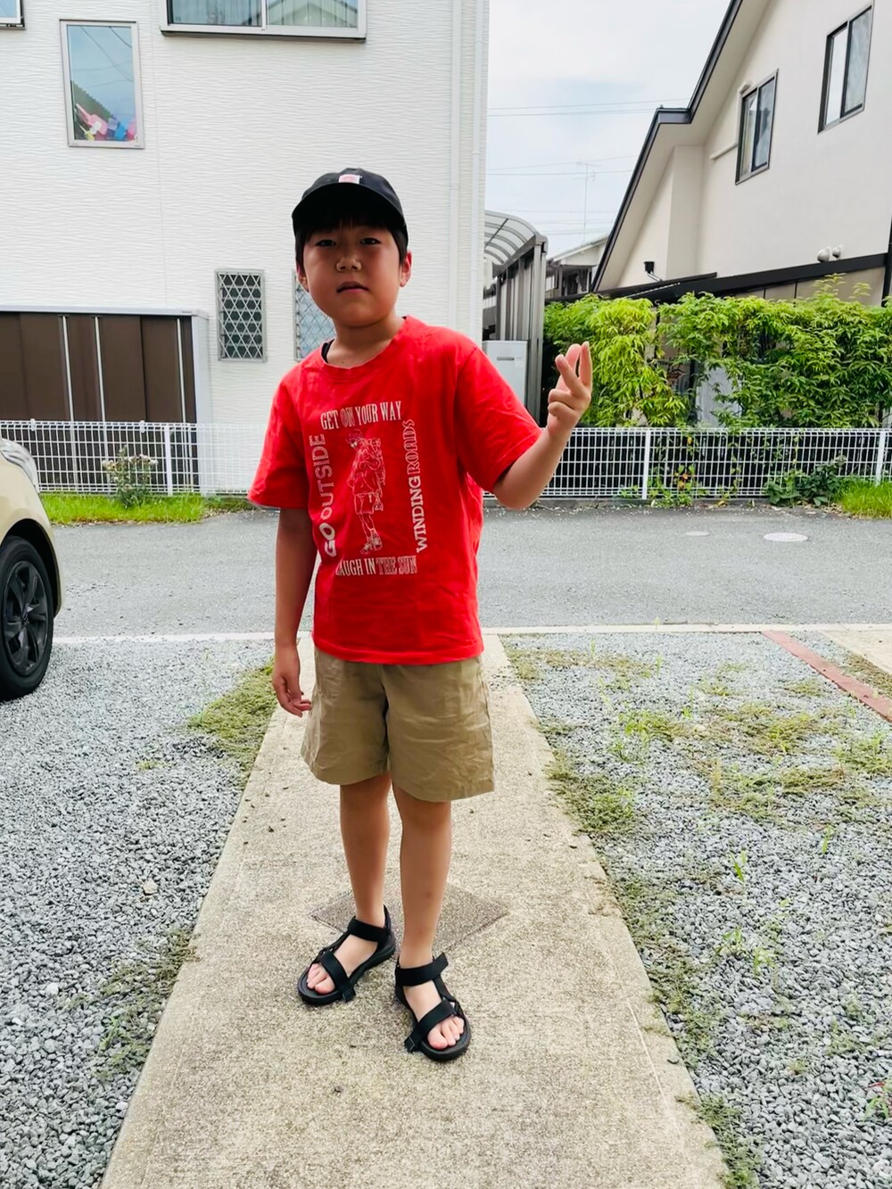 レッド系のTシャツ/カットソー、グリーン系のパンツ、ブラック系のサンダルを着用したキッズの夏コーディネートの2枚目の写真