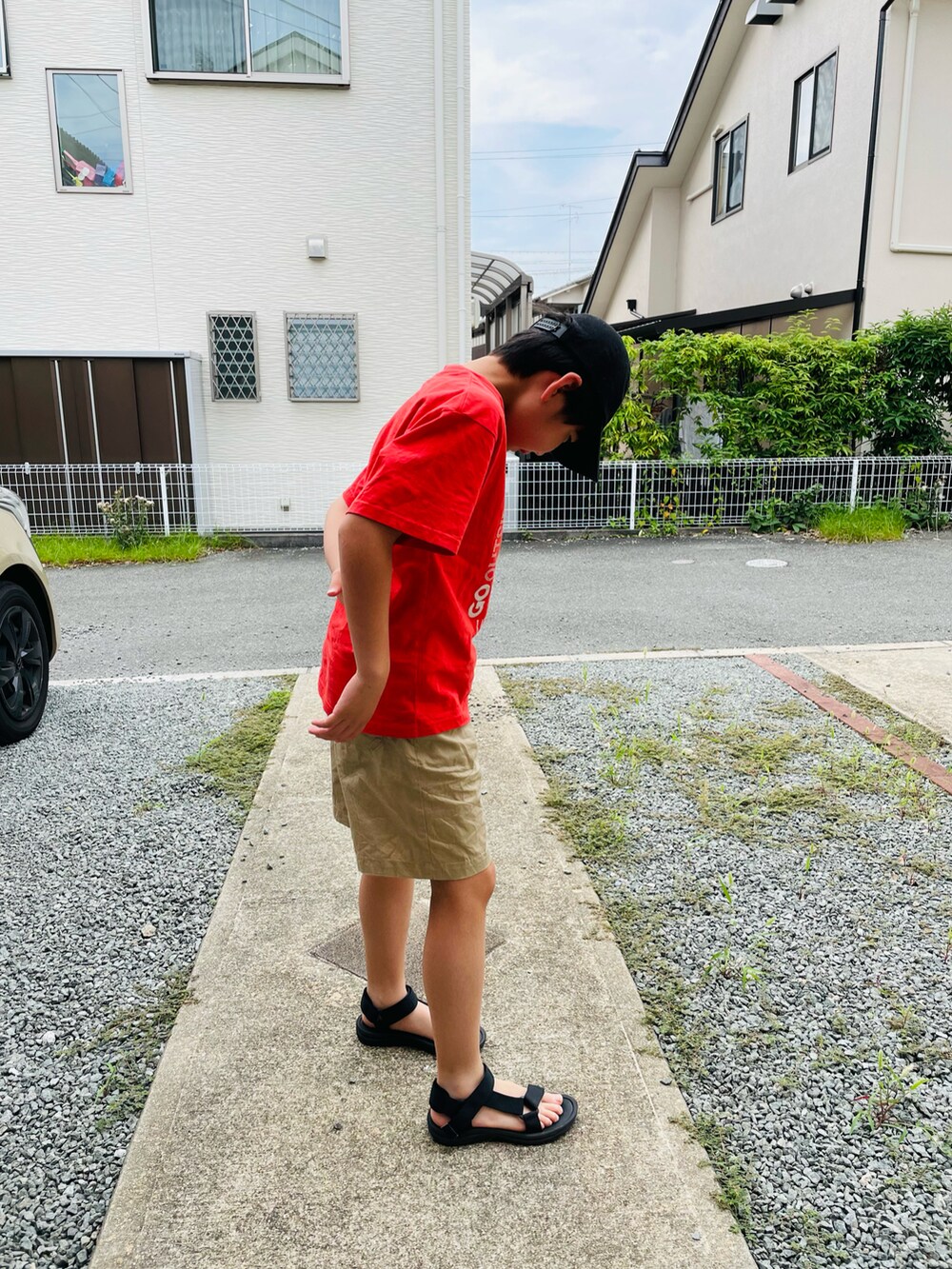 レッド系のTシャツ/カットソー、グリーン系のパンツ、ブラック系のサンダルを着用したキッズの夏コーディネートの3枚目の写真