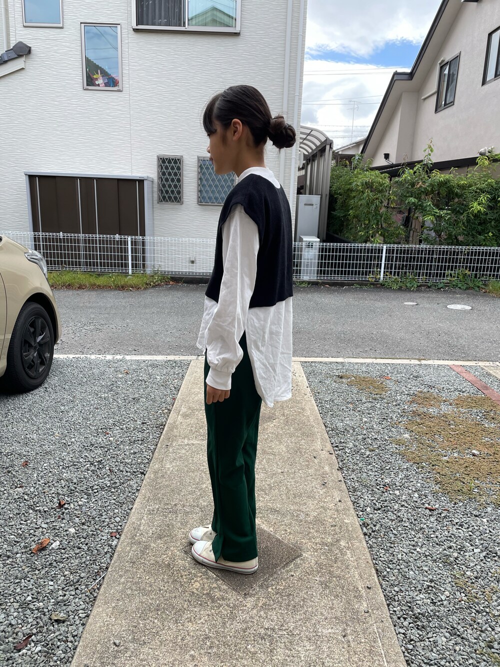 ブラック系のベスト、ベージュ系のTシャツ/カットソー、グリーン系のその他パンツを着用したキッズの秋コーディネートの2枚目の写真
