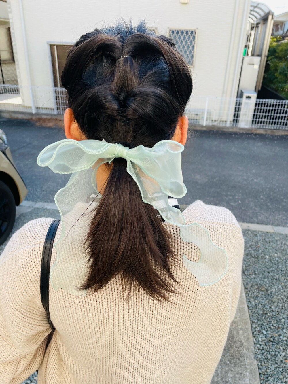 ホワイト系のカーディガン/ボレロ、グリーン系のジャンパースカート、ブラック系のブーツを着用したキッズの冬コーディネートの2枚目の写真