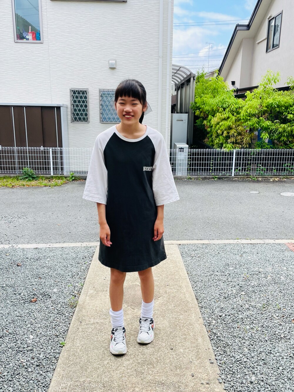 ホワイト系のワンピース、グレー系のスニーカーを着用したキッズの秋コーディネートの3枚目の写真