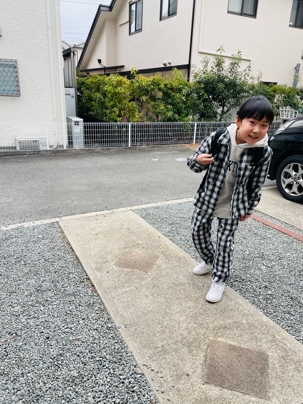 ブラック系のバックパック/リュック、グレー系のTシャツ/カットソー、ホワイト系のスニーカーを着用したキッズの冬コーディネートの2枚目の写真