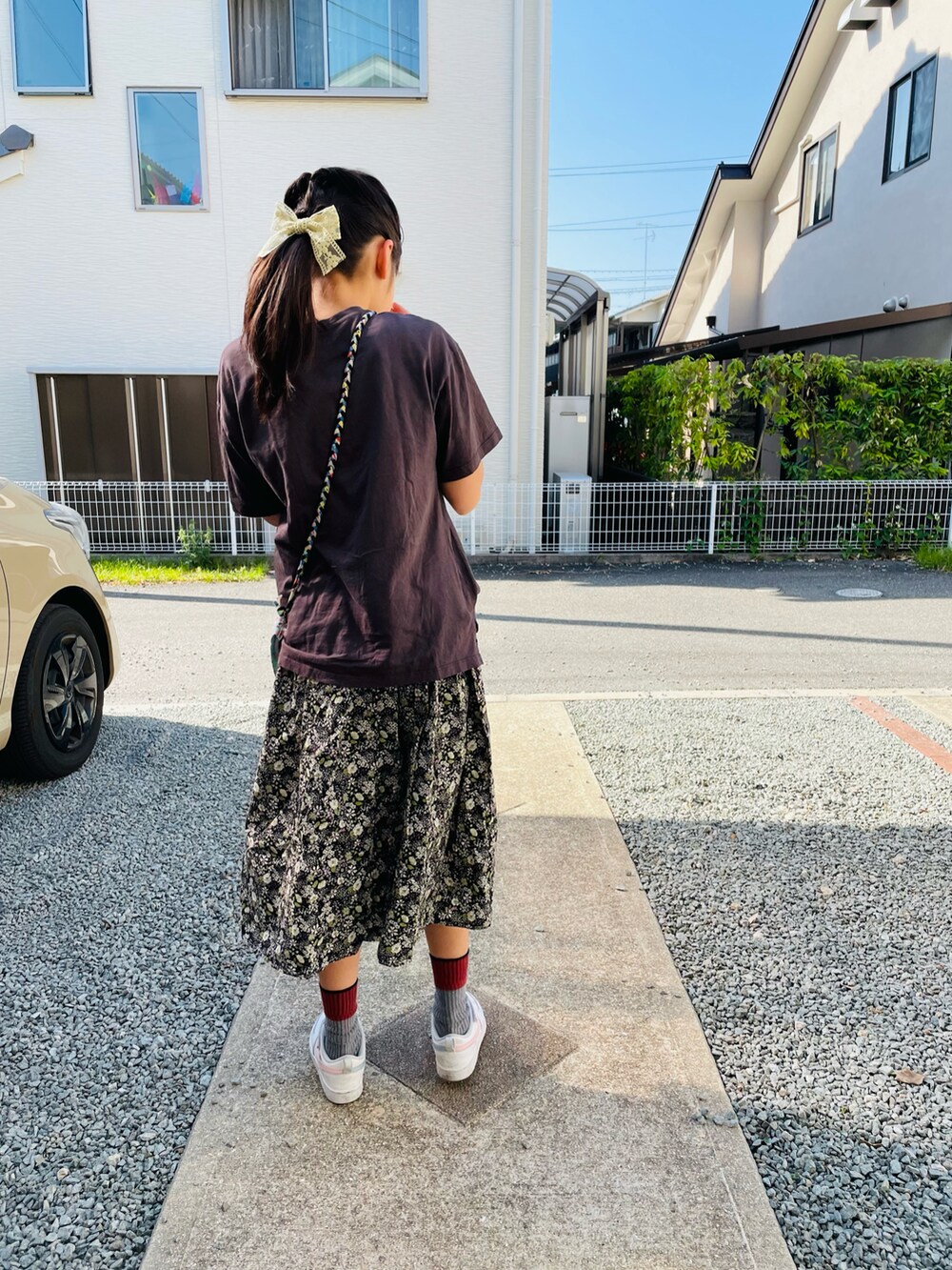 ブラック系のスカート、グレー系のTシャツ/カットソー、ホワイト系のスニーカーを着用したキッズの夏コーディネートの2枚目の写真