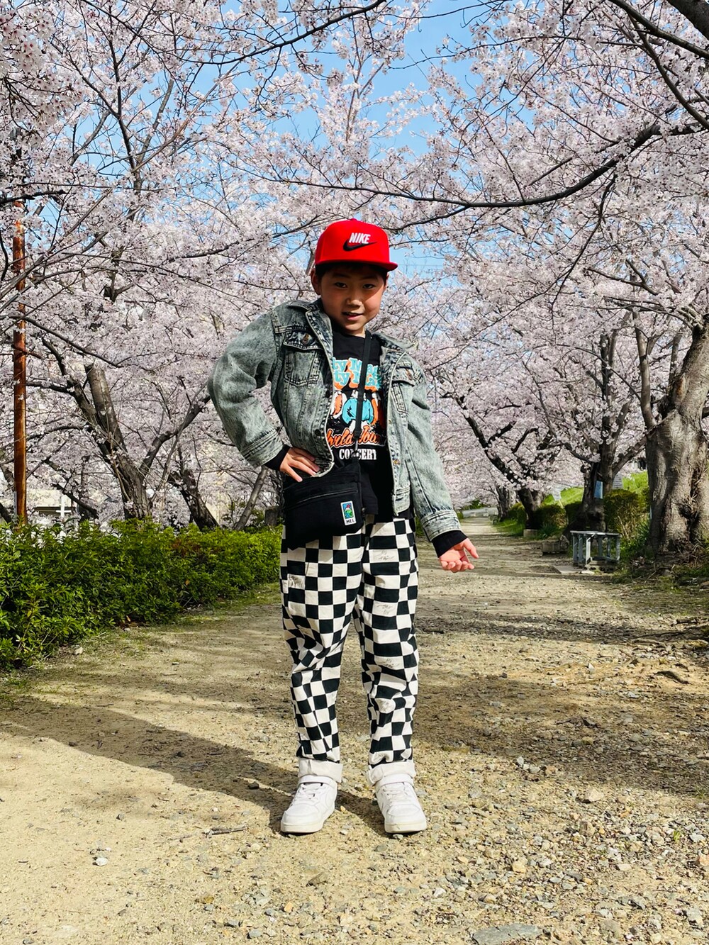 ブルー系のデニムジャケット、ブラック系のその他パンツ、ホワイト系のスニーカーを着用したキッズの春コーディネートの2枚目の写真