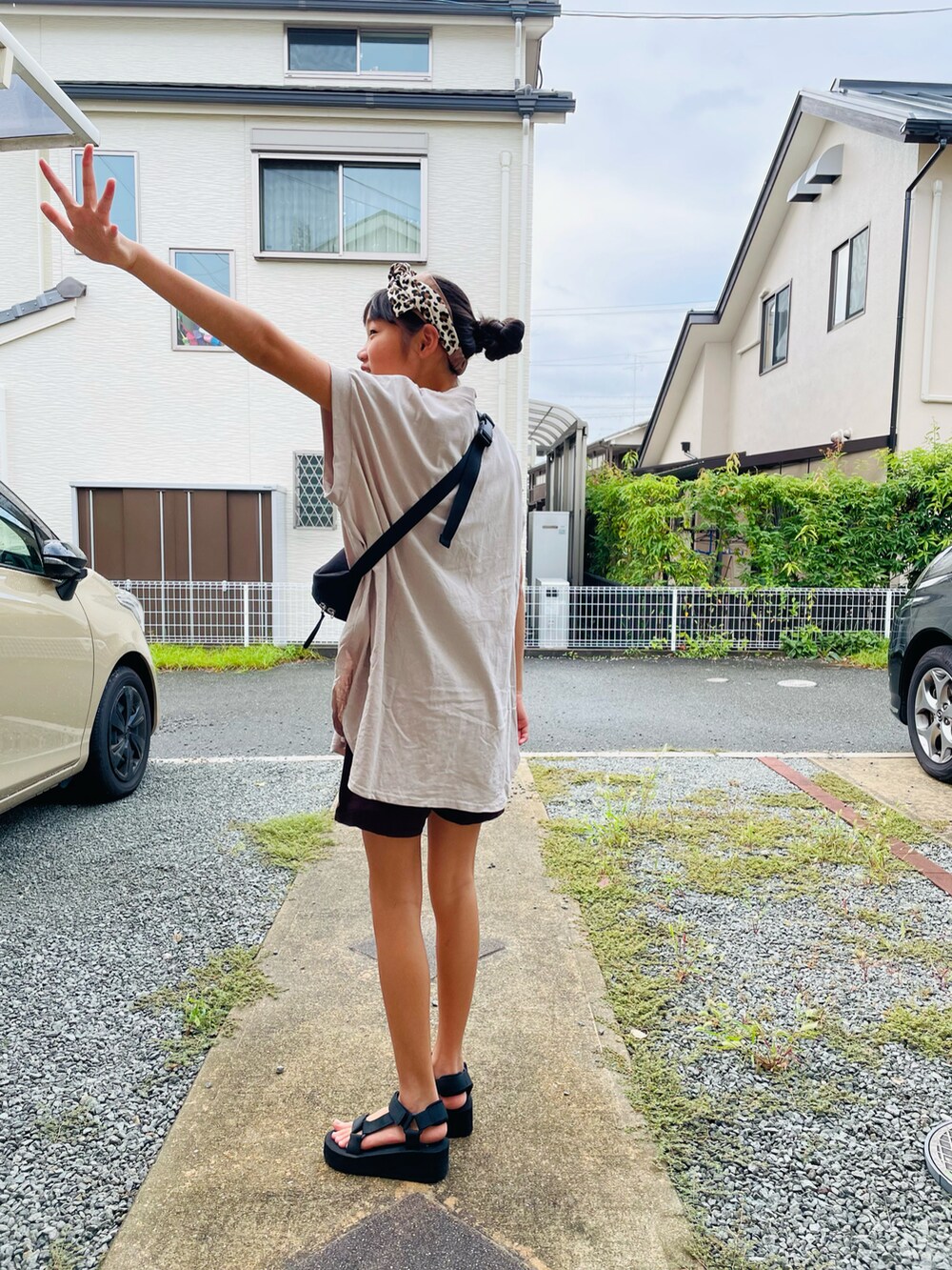 ベージュ系のTシャツ/カットソー、ブラック系のボディバッグ/ウエストポーチ、ブラック系のサンダルを着用したキッズの秋コーディネートの2枚目の写真