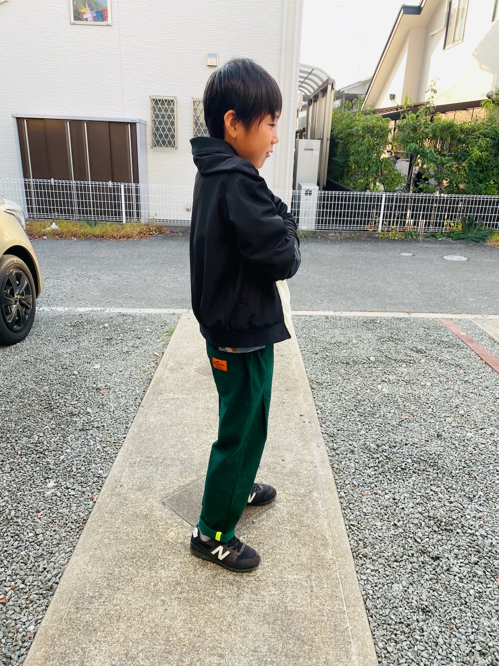 グリーン系のその他パンツ、ブラック系のスニーカー、ホワイト系のスウェットを着用したキッズの秋コーディネートの2枚目の写真