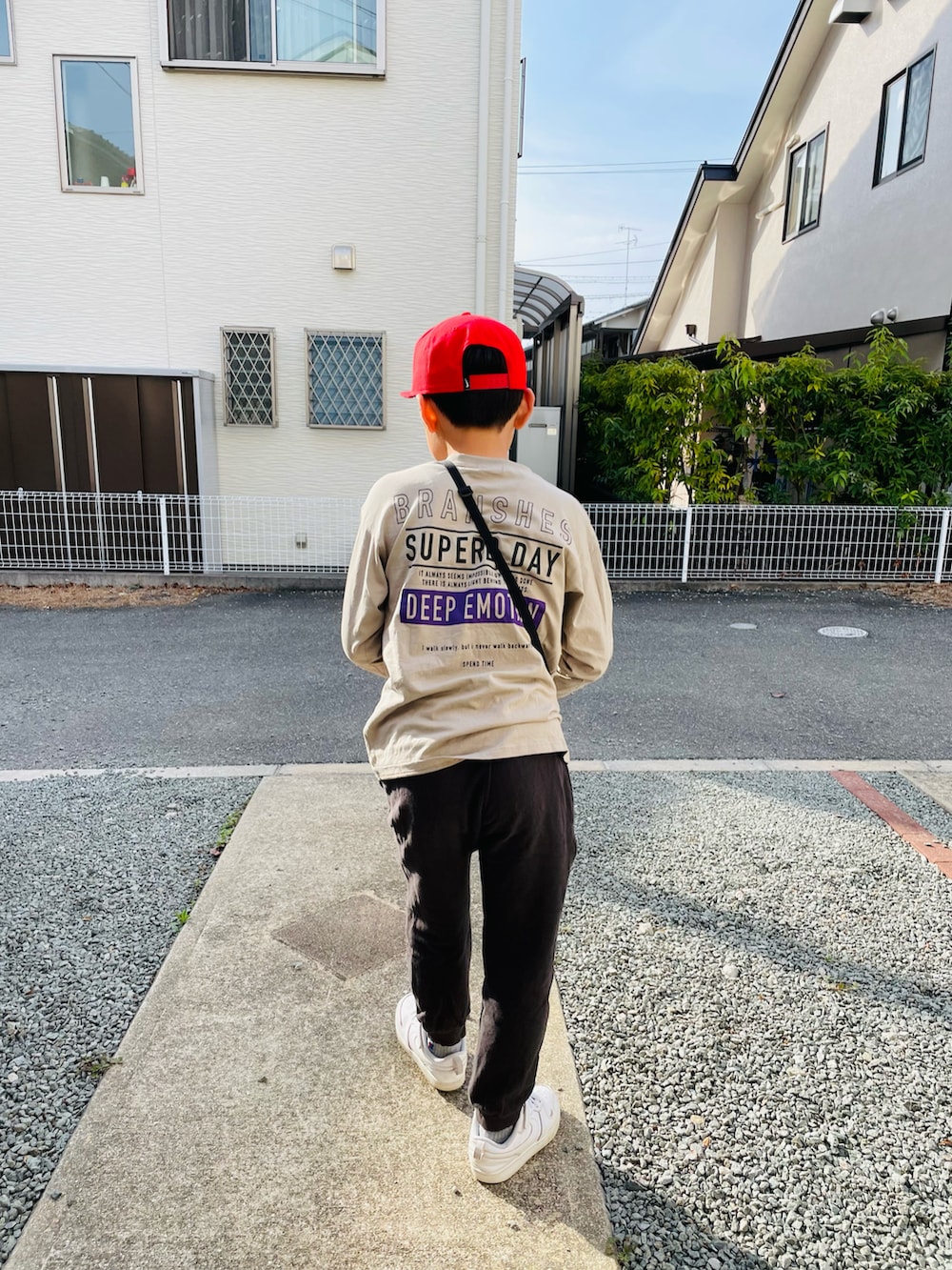グレー系のその他パンツ、ホワイト系のスニーカー、ベージュ系のTシャツ/カットソーを着用したキッズの春コーディネートの2枚目の写真