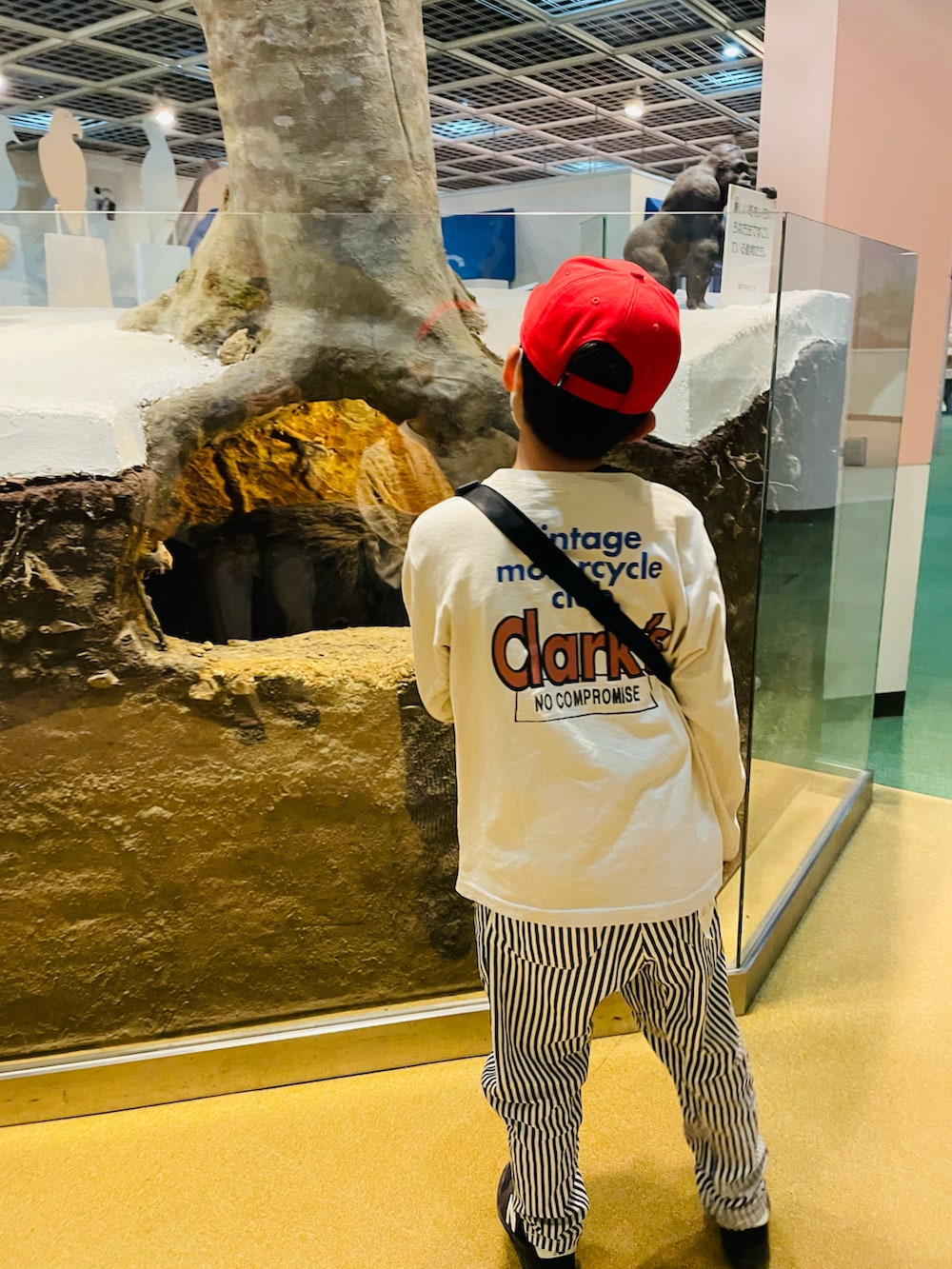 ブラック系のボディバッグ/ウエストポーチ、ホワイト系のその他パンツ、ブラック系のスニーカーを着用したキッズの春コーディネートの2枚目の写真