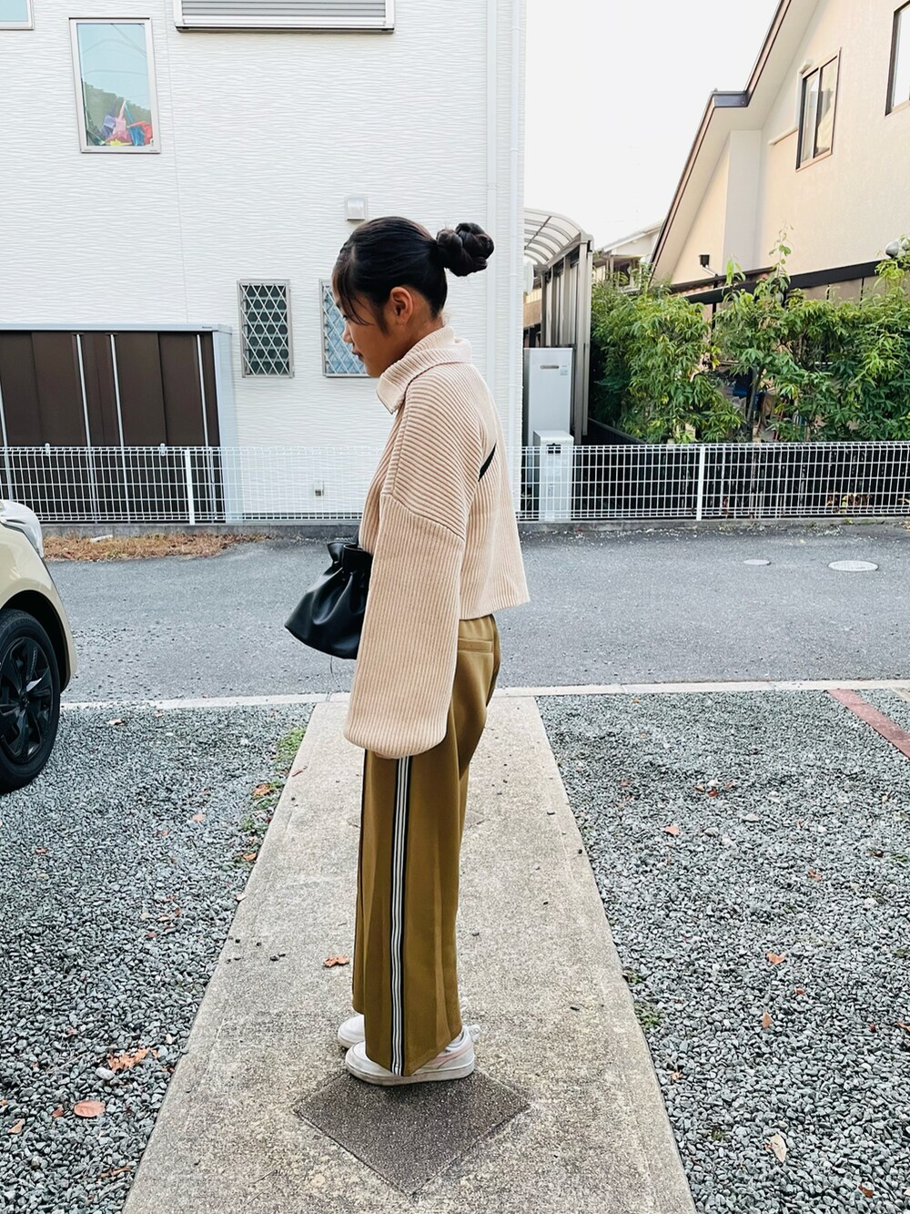 ブラック系のハンドバッグ、ホワイト系のニット/セーター、ベージュ系のその他パンツを着用したキッズの冬コーディネートの2枚目の写真