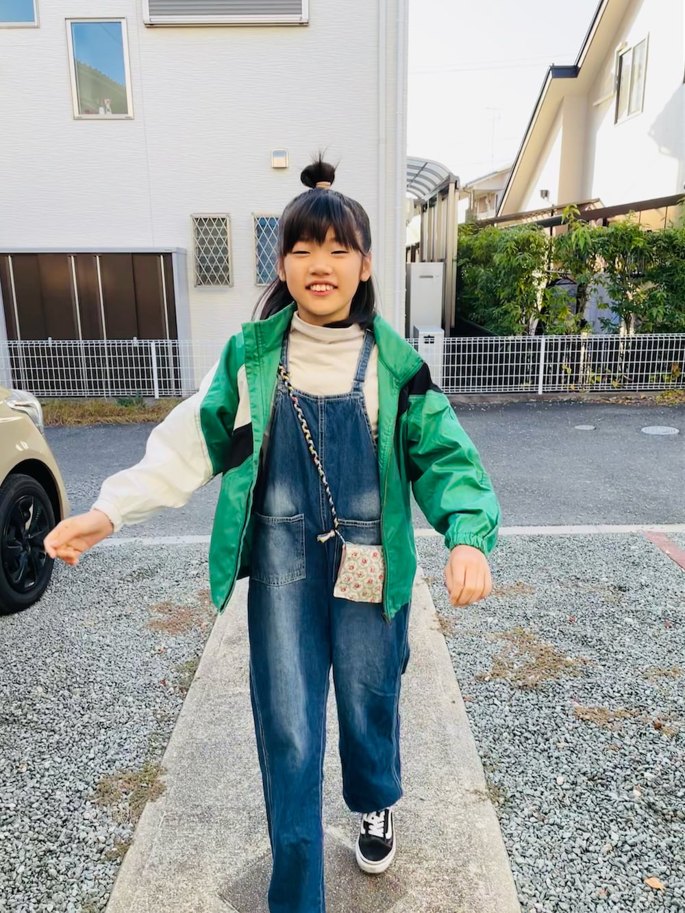グリーン系のその他アウター、ブラック系のスニーカー、ブルー系のサロペット/オーバーオールを着用したキッズの秋コーディネートの3枚目の写真