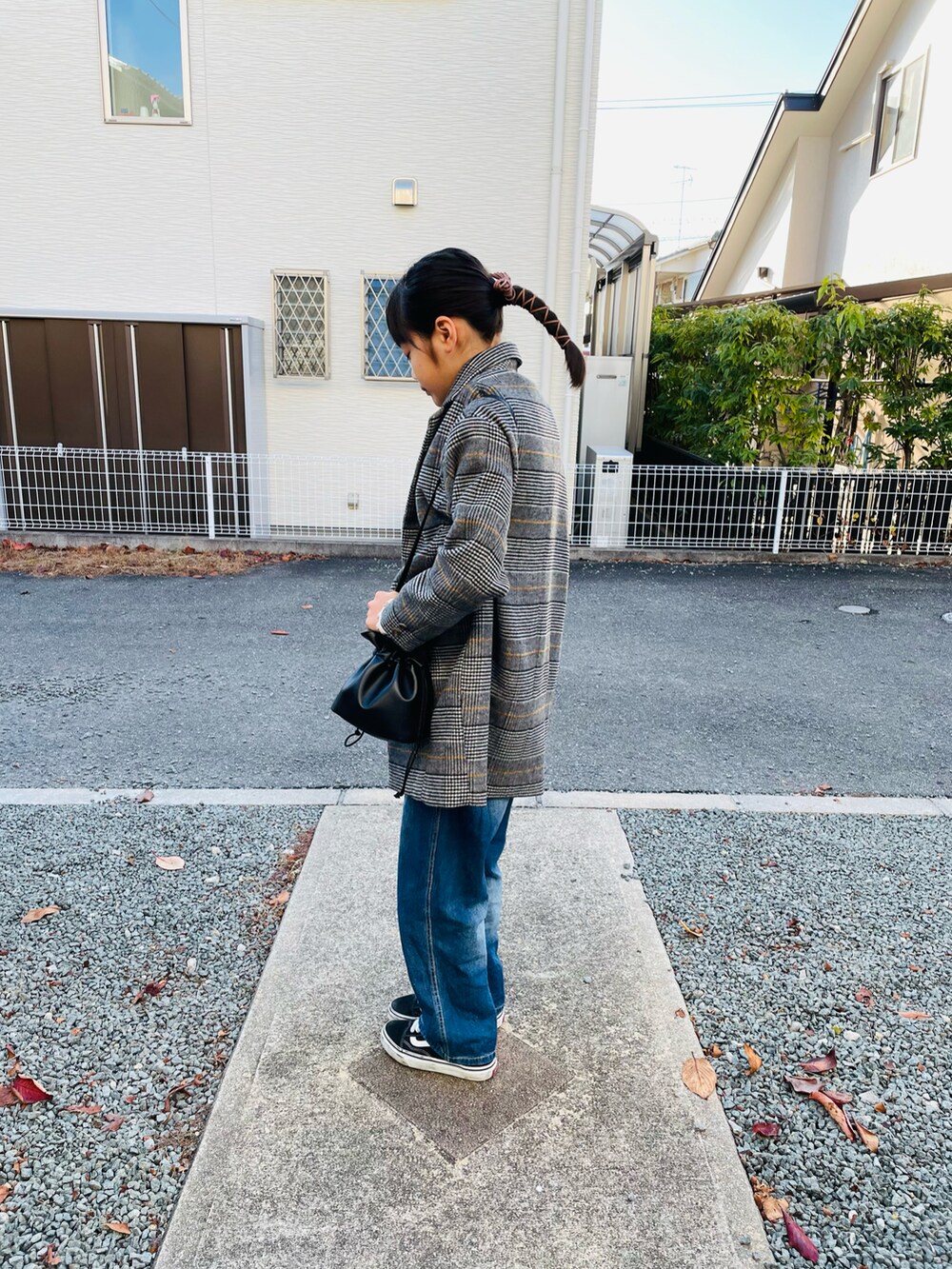 グレー系のチェスターコート、ブラック系のハンドバッグ、ブルー系のサロペット/オーバーオールを着用したキッズの冬コーディネートの2枚目の写真