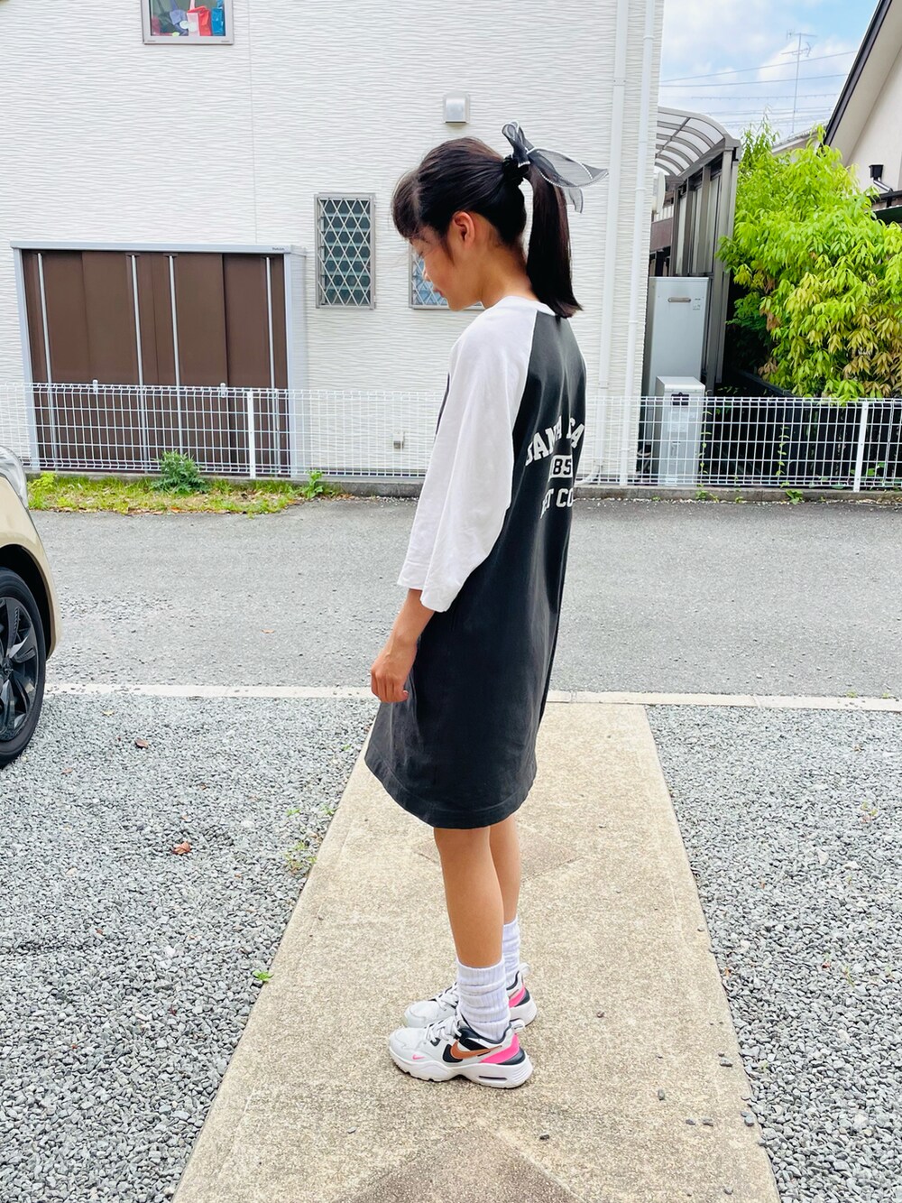 ホワイト系のワンピース、グレー系のスニーカーを着用したキッズの秋コーディネートの2枚目の写真