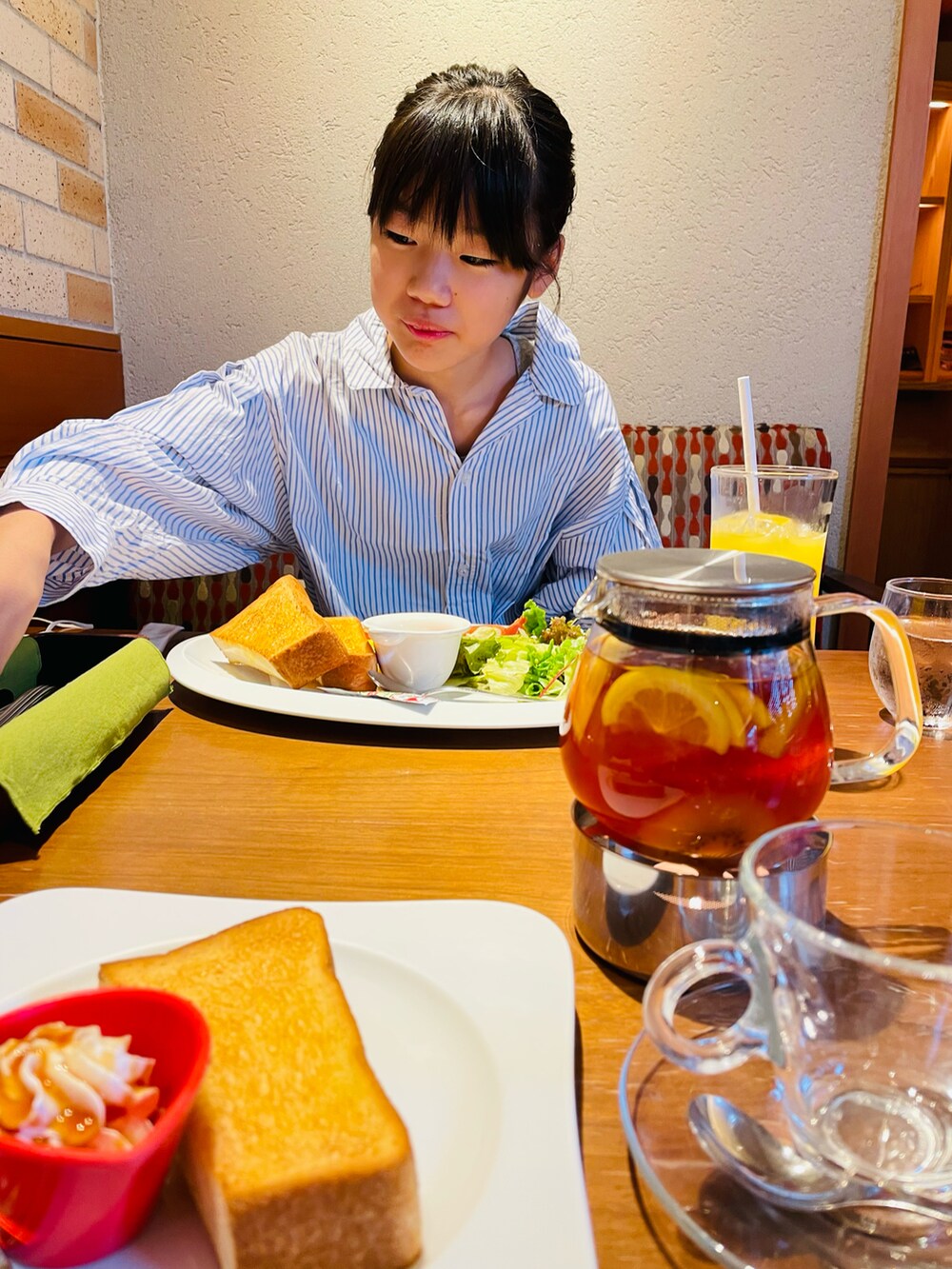 ブラック系のショルダーバッグ、ブルー系のシャツワンピース、ブルー系のデニムパンツを着用したキッズの秋コーディネートの5枚目の写真