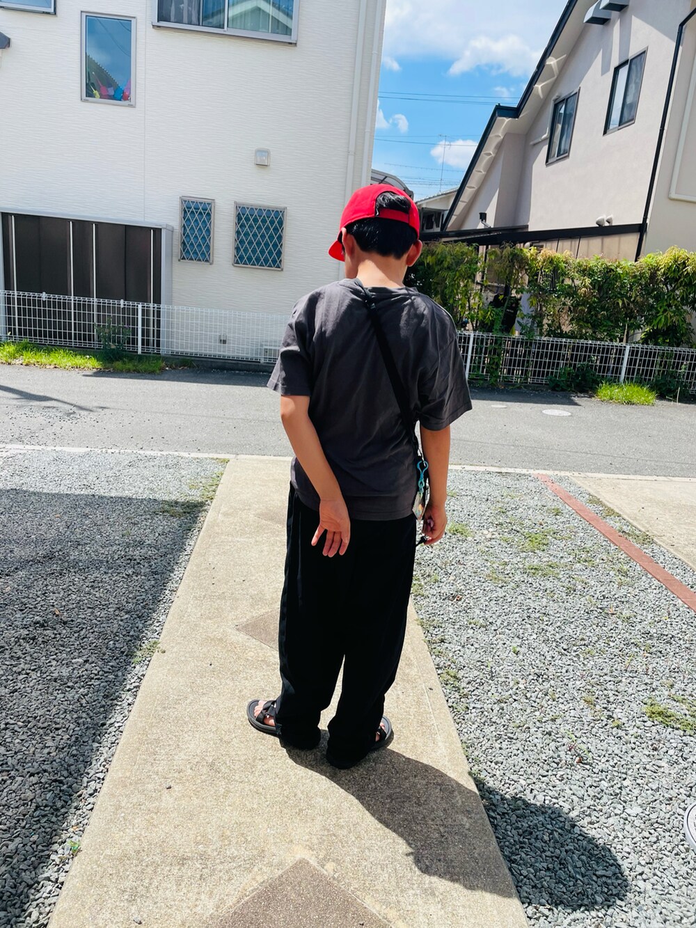 グレー系のTシャツ/カットソー、ブラック系のその他パンツ、ブラック系のサンダルを着用したキッズの夏コーディネートの2枚目の写真