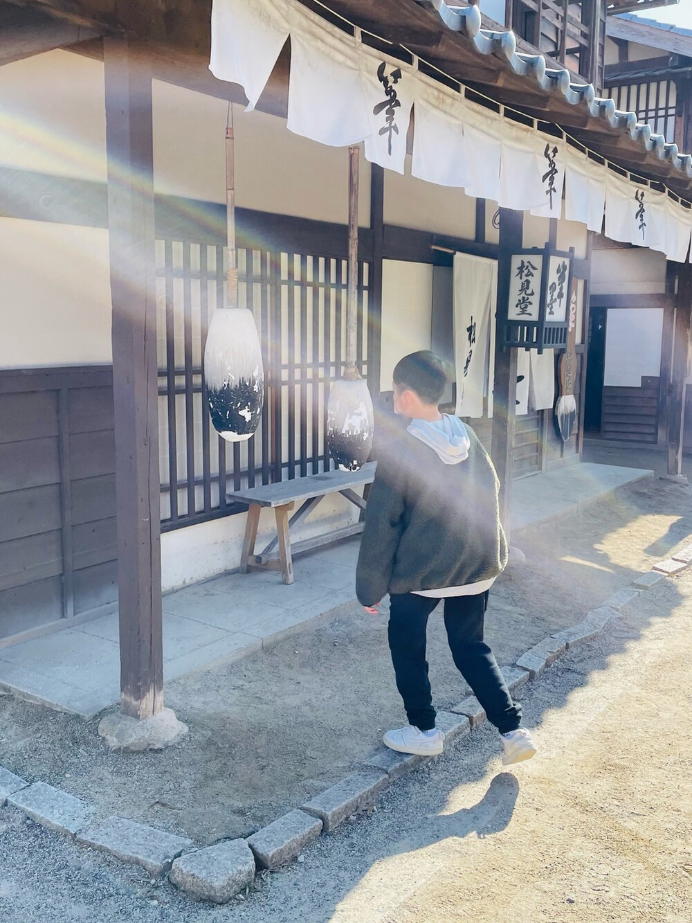 ブラック系のボディバッグ/ウエストポーチ、グレー系のパーカー、ブラック系のその他パンツを着用したキッズの冬コーディネートの3枚目の写真