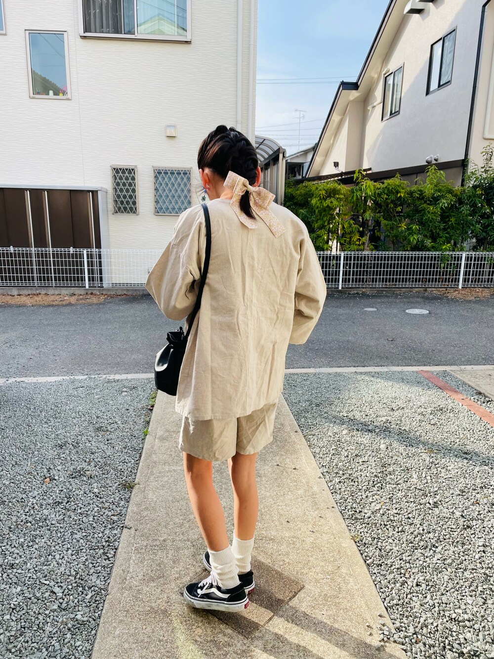 ベージュ系のジャケット/アウター、オレンジ系のTシャツ/カットソー、ブラック系のハンドバッグを着用したキッズの春コーディネートの3枚目の写真