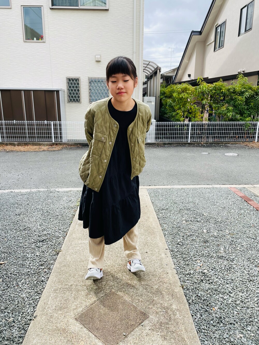 グリーン系のブルゾン、ブラック系のワンピース、ベージュ系のその他パンツを着用したキッズの春コーディネートの3枚目の写真