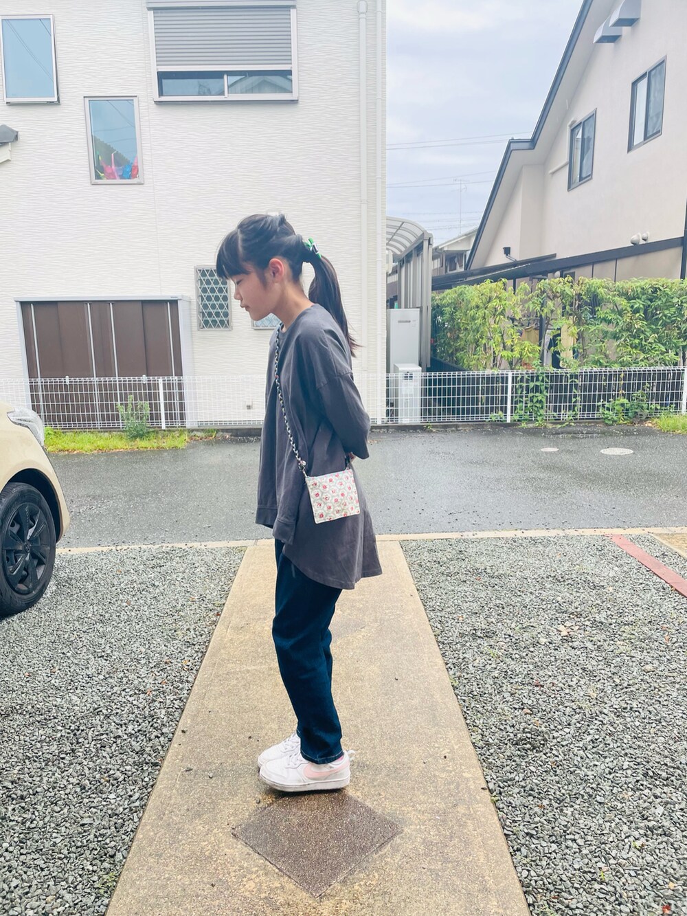 ブルー系のデニムパンツ、ホワイト系のスニーカー、グレー系のチュニックを着用したキッズの夏コーディネートの2枚目の写真