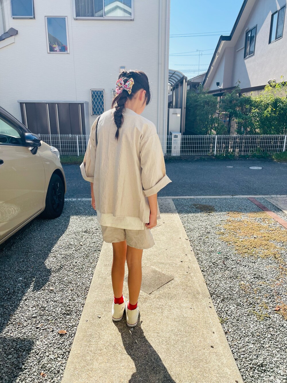 ベージュ系のジャケット/アウター、ホワイト系のTシャツ/カットソー、ブラック系のハンドバッグを着用したキッズの秋コーディネートの3枚目の写真