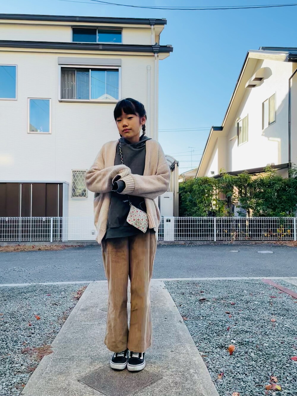 グレー系のパーカー、ホワイト系のカーディガン/ボレロ、ベージュ系のその他パンツを着用したキッズの冬コーディネートの3枚目の写真