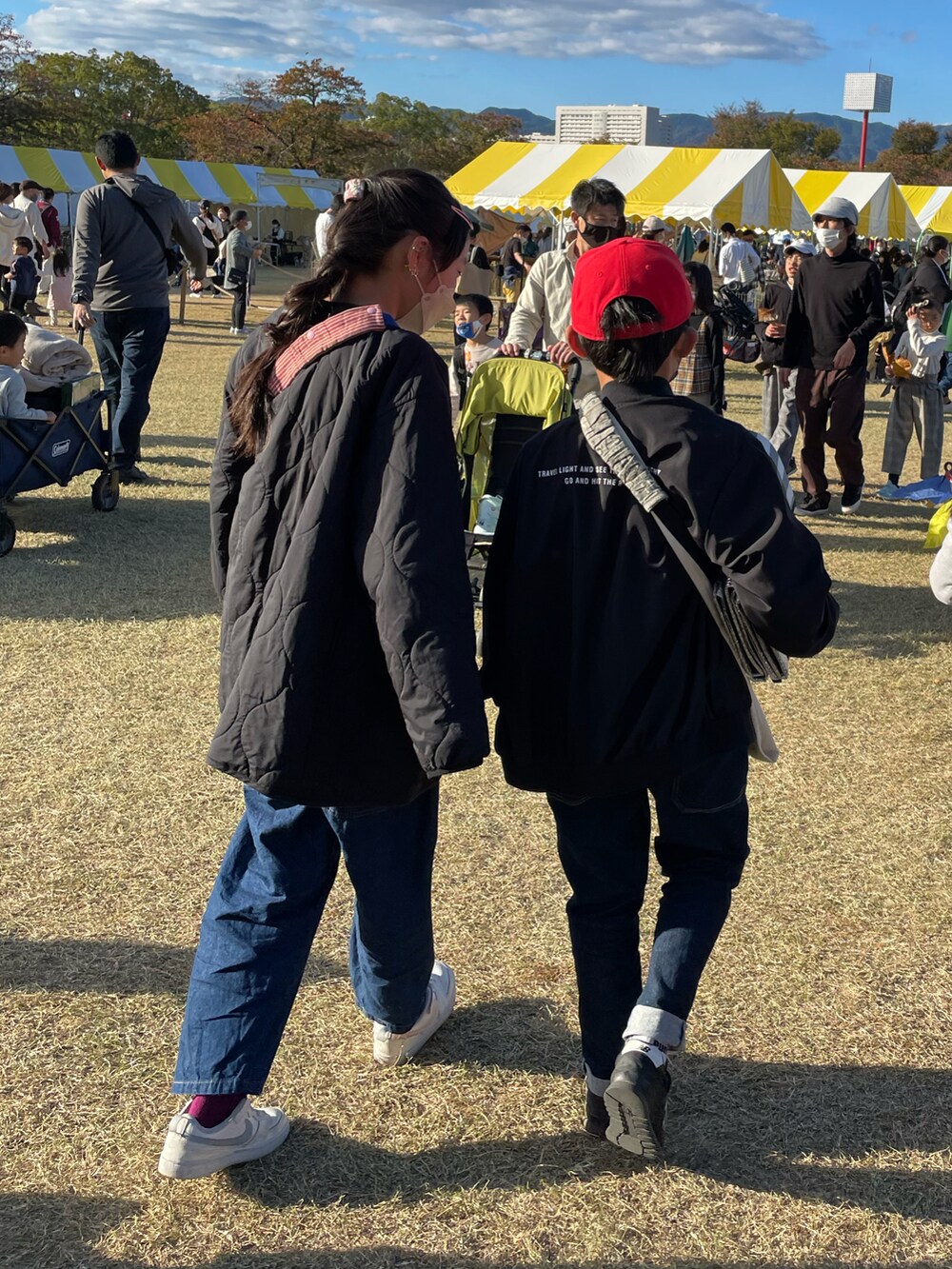 ブルー系のデニムパンツ、ホワイト系のスニーカー、ベージュ系のスウェットを着用したキッズの秋コーディネートの4枚目の写真