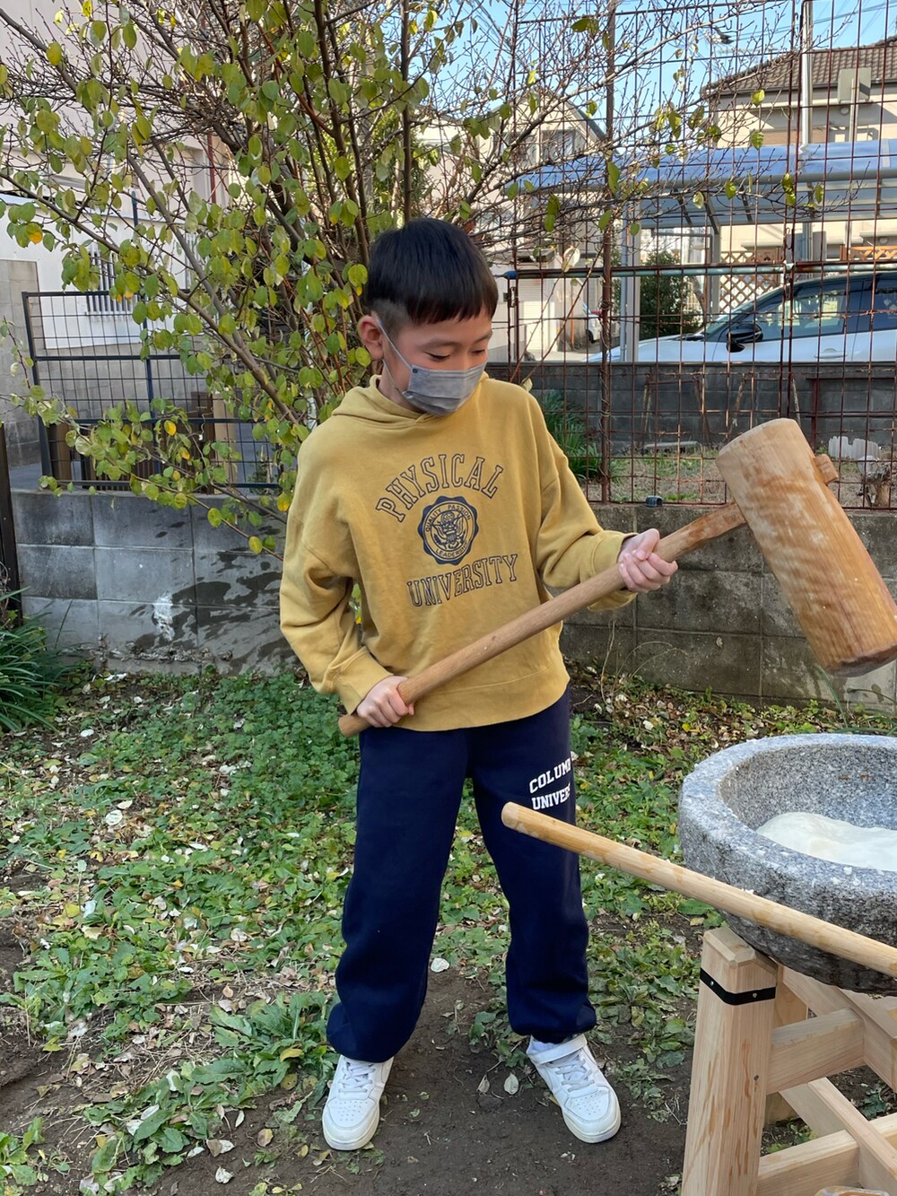 イエロー系のスウェット、ブルー系のスウェットパンツ、ホワイト系のスニーカーを着用したキッズの冬コーディネートの3枚目の写真