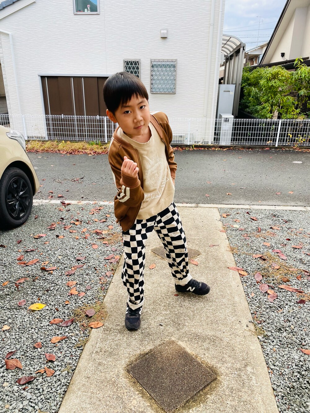 ベージュ系のスウェット、ブラウン系のノーカラージャケット、ブラック系のその他パンツを着用したキッズの秋コーディネートの3枚目の写真