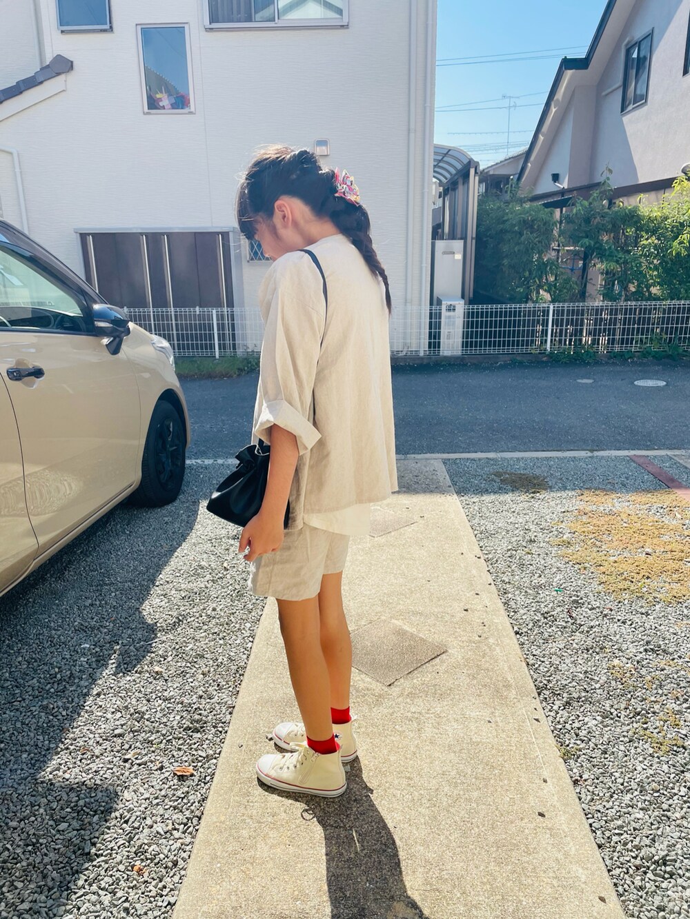 ベージュ系のジャケット/アウター、ホワイト系のTシャツ/カットソー、ブラック系のハンドバッグを着用したキッズの秋コーディネートの2枚目の写真