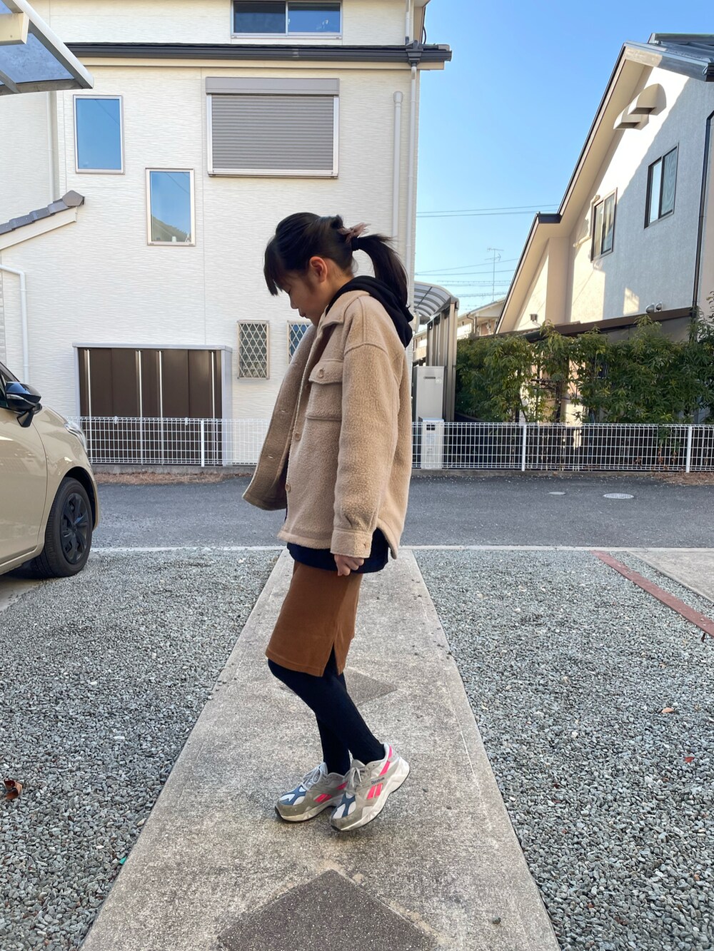 ベージュ系のその他アウター、ブラウン系のスカート、グレー系のスニーカーを着用したキッズの春コーディネートの2枚目の写真