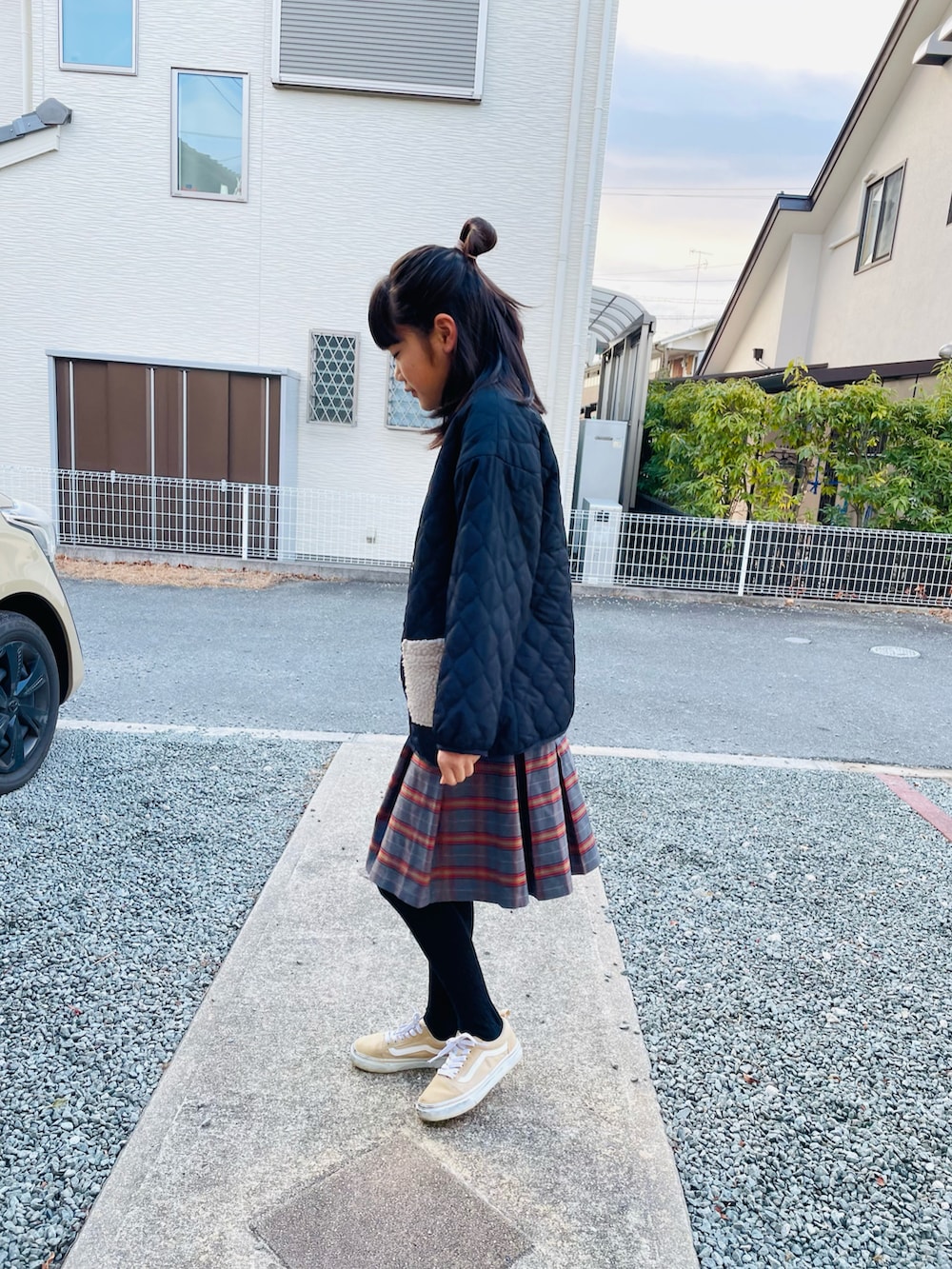 ブラック系のニット/セーター、グレー系のスカート、ブラック系のブルゾンを着用したキッズの冬コーディネートの2枚目の写真