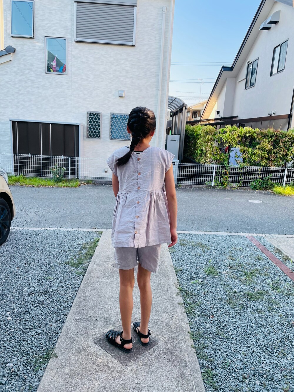 ピンク系のオールインワン・サロペット、ブラック系のサンダル、ブラック系のタンクトップを着用したキッズの夏コーディネートの3枚目の写真