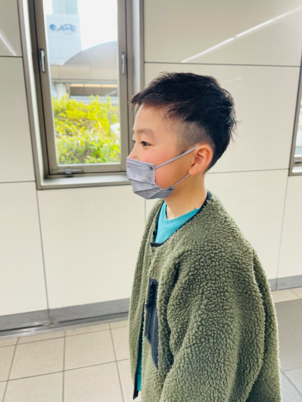 グリーン系のその他アウター、ホワイト系のその他パンツ、ブラック系のスニーカーを着用したキッズの冬コーディネートの3枚目の写真