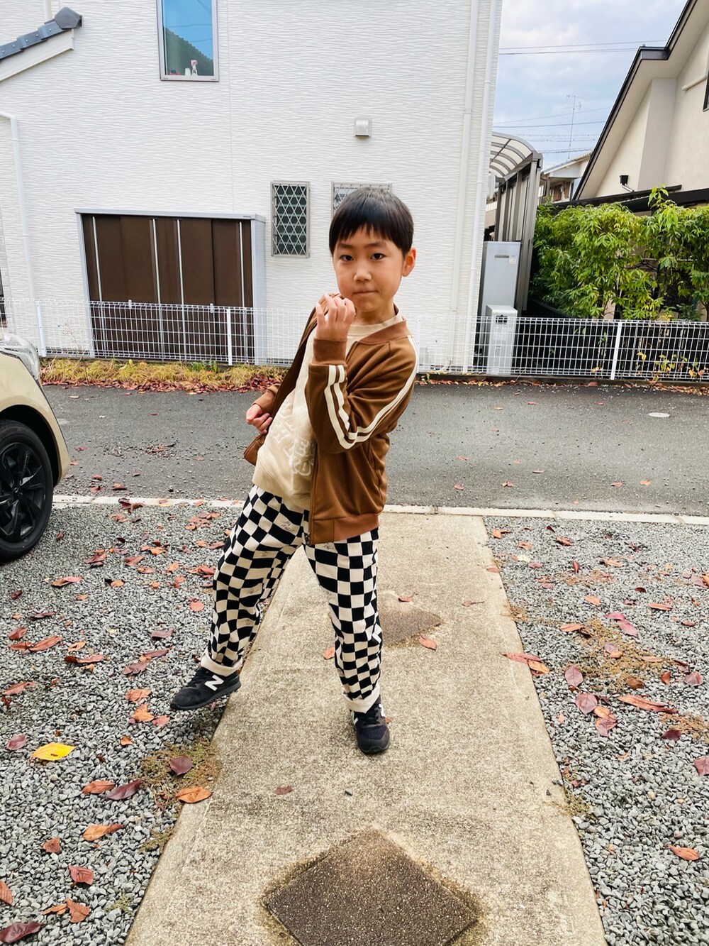 ベージュ系のスウェット、ブラウン系のノーカラージャケット、ブラック系のその他パンツを着用したキッズの秋コーディネートの4枚目の写真