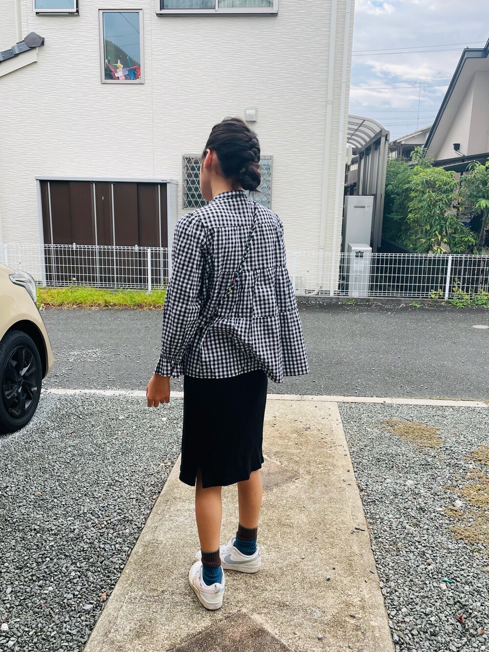 ブラック系のシャツ/ブラウス、ブラック系のスカート、ホワイト系のスニーカーを着用したキッズの秋コーディネートの2枚目の写真