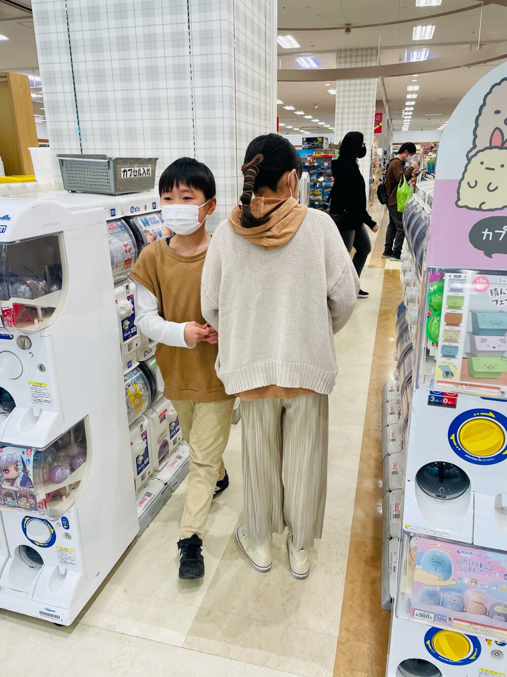 ベージュ系のその他パンツ、ブラウン系のパーカー、ホワイト系のカーディガン/ボレロを着用したキッズの冬コーディネートの5枚目の写真