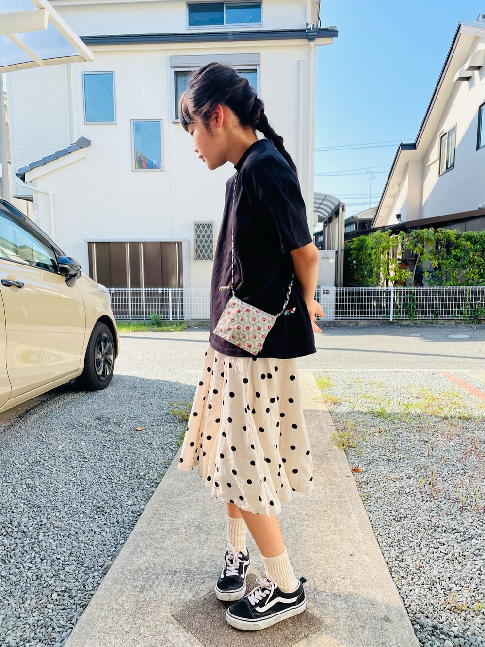 ブラック系のTシャツ/カットソー、ホワイト系のスカート、ブラック系のスニーカーを着用したキッズの夏コーディネートの2枚目の写真