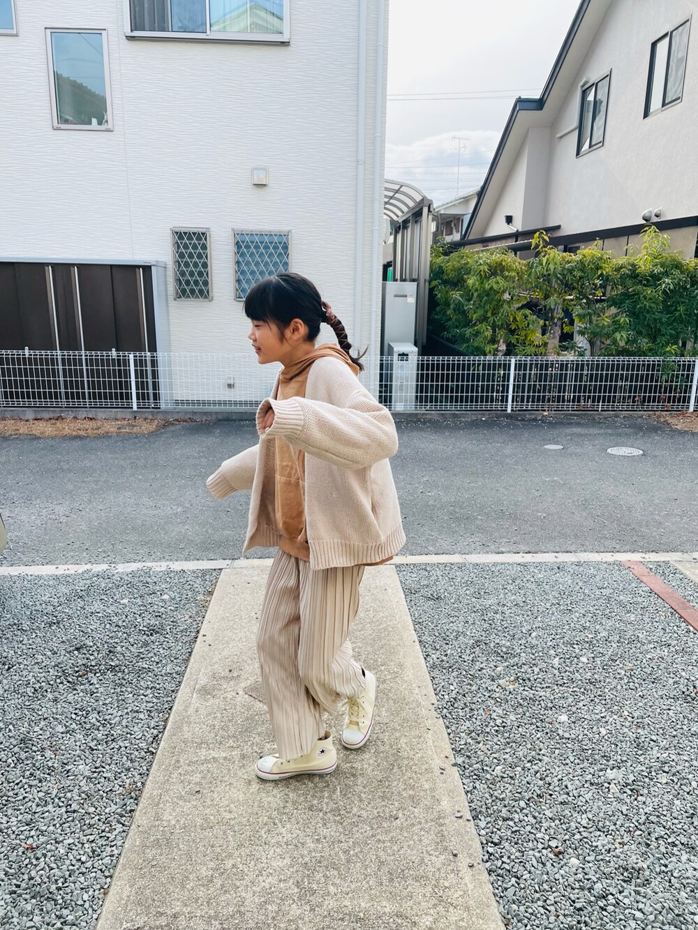 ベージュ系のその他パンツ、ブラウン系のパーカー、ホワイト系のカーディガン/ボレロを着用したキッズの冬コーディネートの2枚目の写真