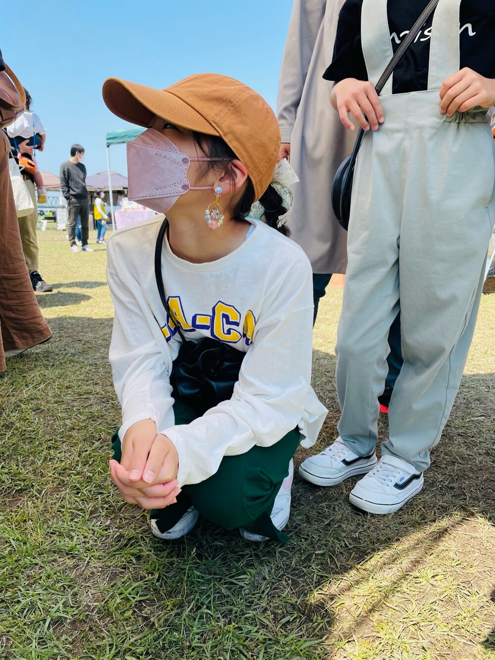 グリーン系のその他パンツ、ホワイト系のTシャツ/カットソー、ブラック系のハンドバッグを着用したキッズの春コーディネートの3枚目の写真