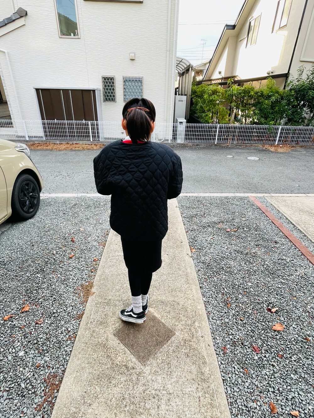 ブラック系のブルゾン、ブラック系のスカート、ブラック系のスニーカーを着用したキッズの冬コーディネートの3枚目の写真