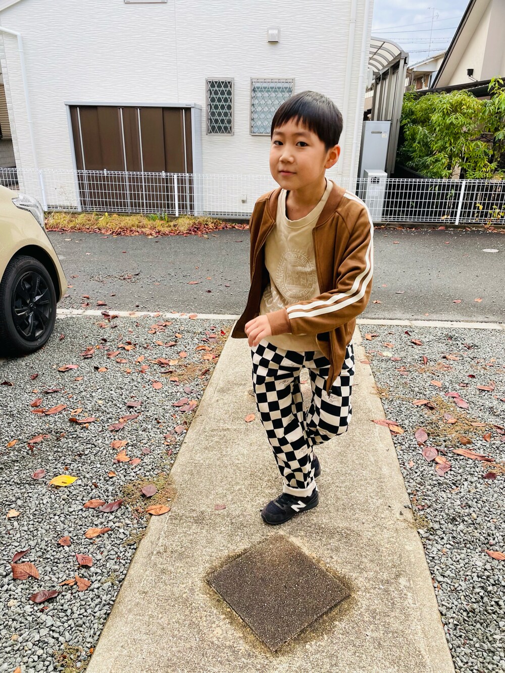 ベージュ系のスウェット、ブラウン系のノーカラージャケット、ブラック系のその他パンツを着用したキッズの秋コーディネートの2枚目の写真