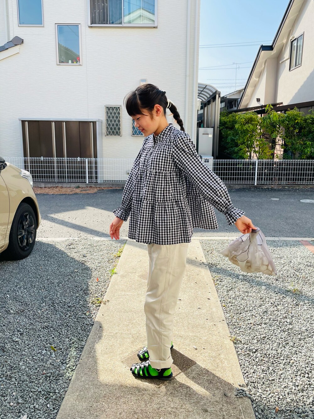 ブラック系のシャツ/ブラウス、ホワイト系のチノパンツ、ブラック系のサンダルを着用したキッズの春コーディネートの2枚目の写真