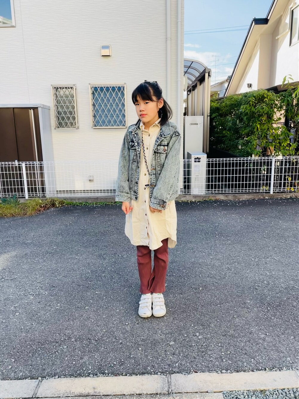 ブルー系のデニムジャケット、ブラウン系のその他パンツ、ホワイト系のスニーカーを着用したキッズの秋コーディネートの2枚目の写真