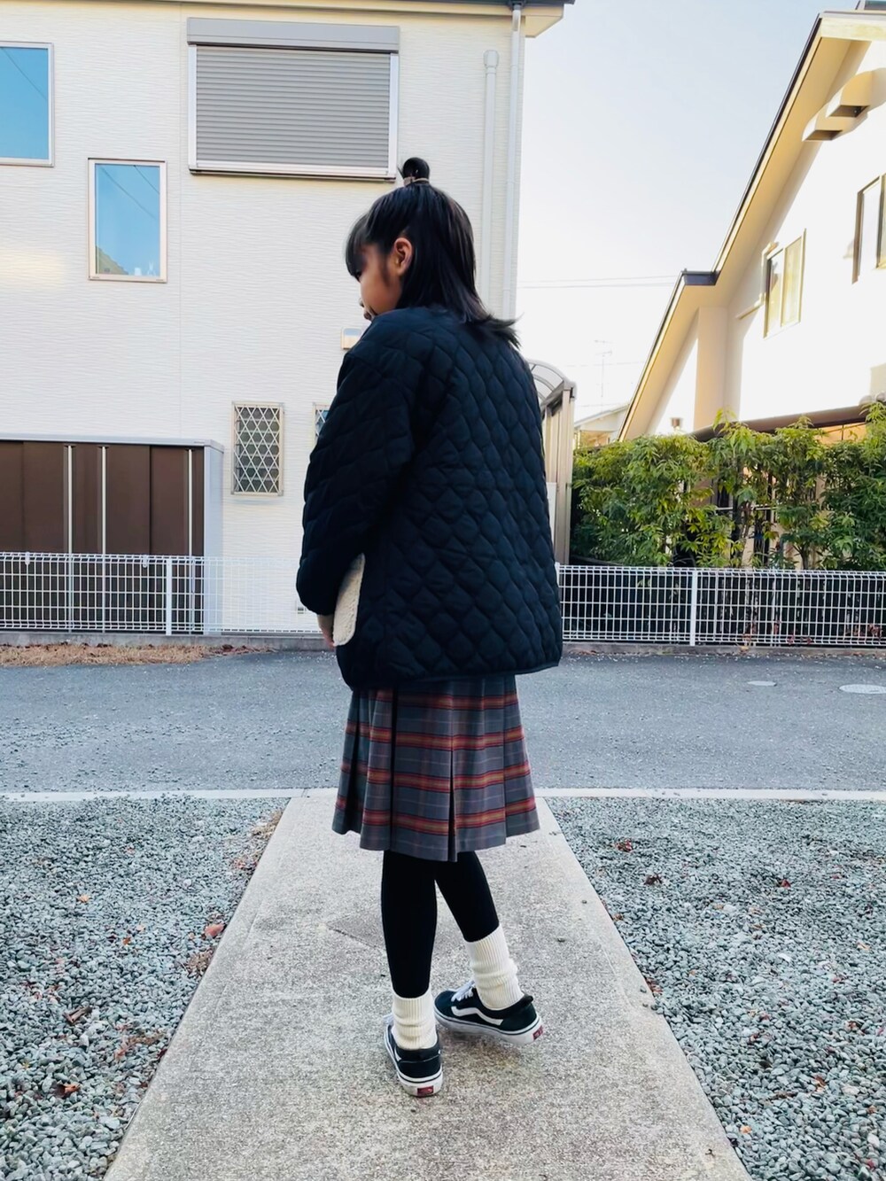 ブラック系のブルゾン、ベージュ系のスウェット、グレー系のスカートを着用したキッズの冬コーディネートの2枚目の写真