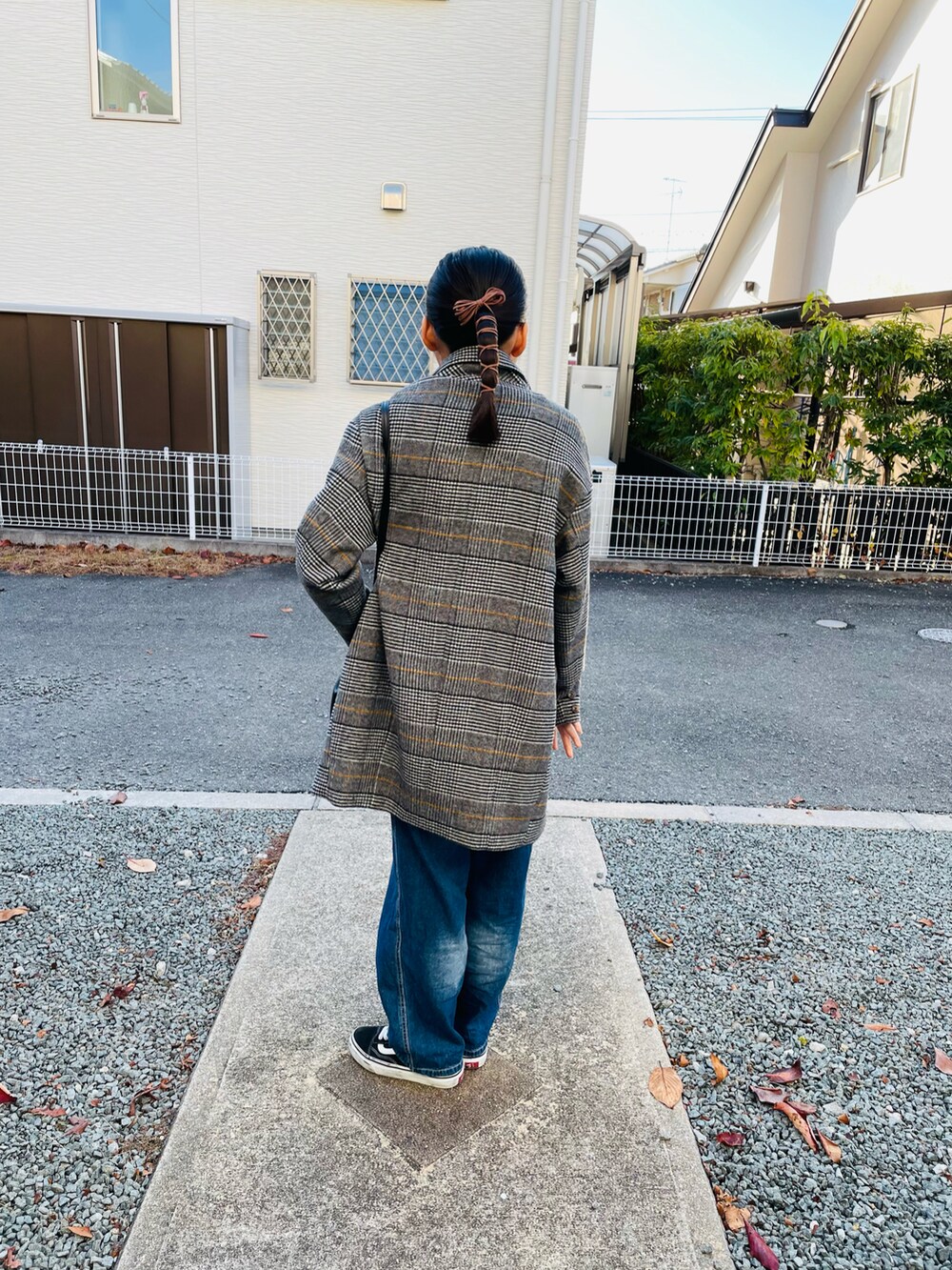 グレー系のチェスターコート、ブラック系のハンドバッグ、ブルー系のサロペット/オーバーオールを着用したキッズの冬コーディネートの3枚目の写真