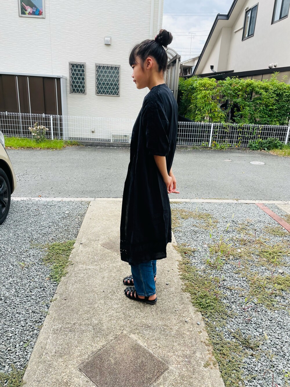 ブラック系のサンダル、ブラック系のワンピース、ブルー系のサロペット/オーバーオールを着用したキッズの夏コーディネートの3枚目の写真