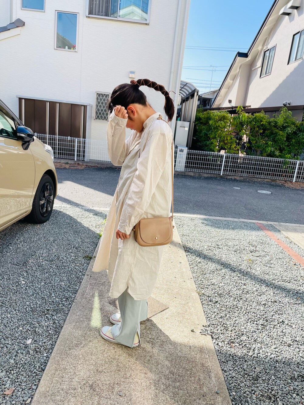 ベージュ系のショルダーバッグ、グリーン系のその他パンツ、ホワイト系のスニーカーを着用したキッズの春コーディネートの2枚目の写真